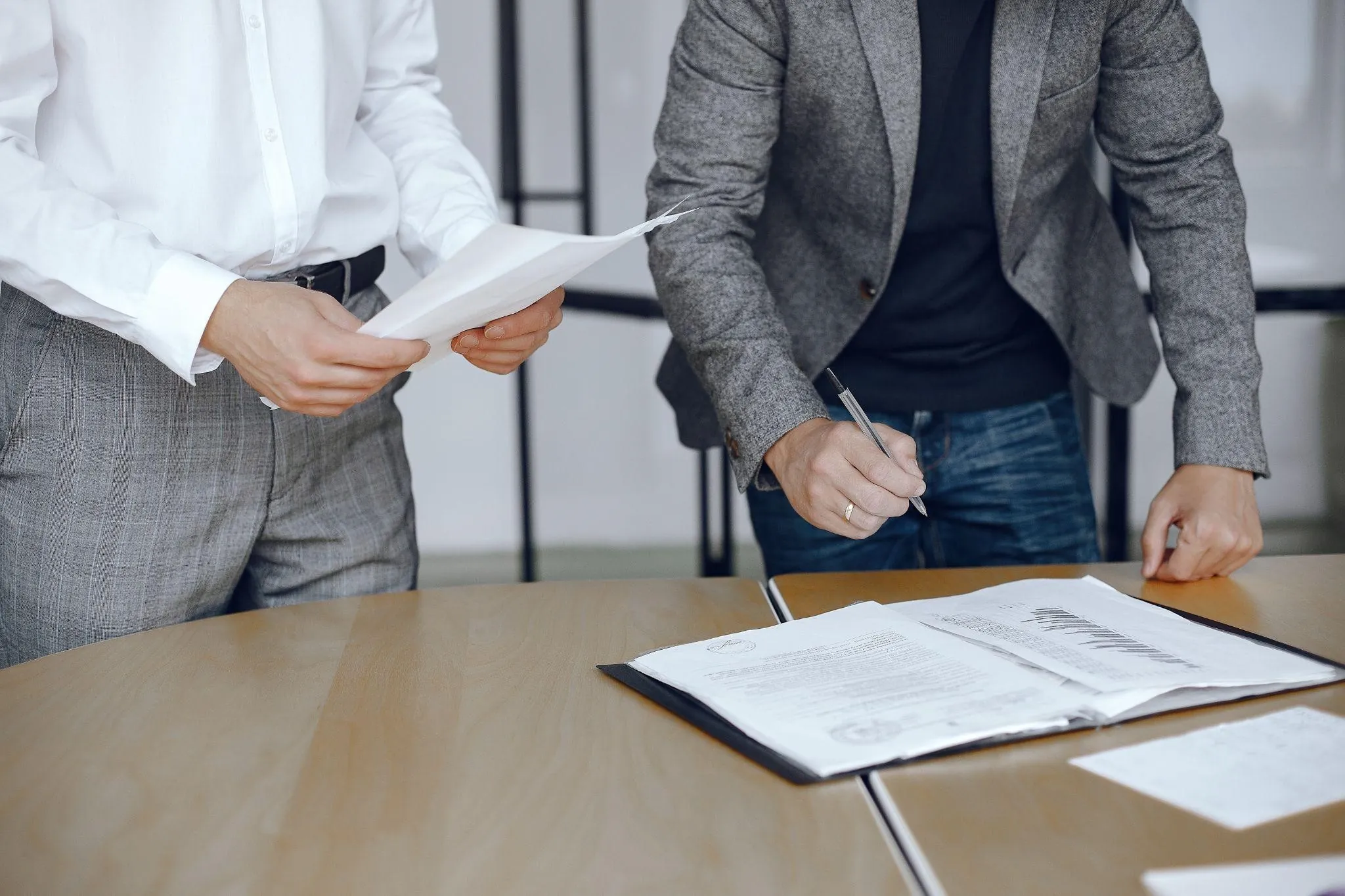 two people signing documents